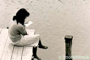 昭和の桟橋で本を読む少女